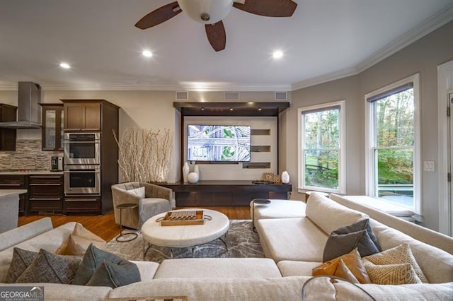 living room featuring ceiling fan, ornamental molding, and dark hardwood / wood-style floors