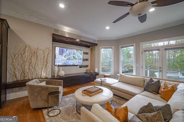 living room featuring hardwood / wood-style flooring, ceiling fan, ornamental molding, and french doors