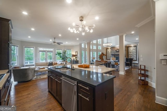 kitchen with sink, stainless steel dishwasher, ornamental molding, dark hardwood / wood-style flooring, and an island with sink