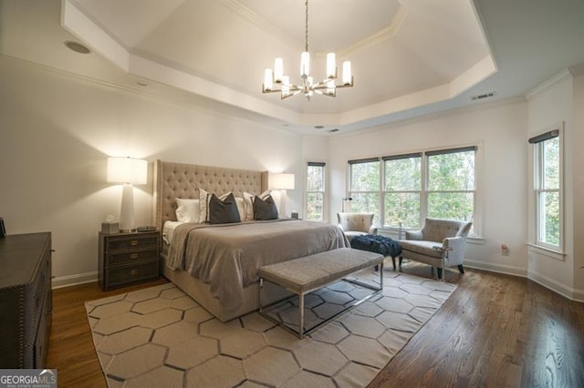 bedroom featuring a chandelier, ornamental molding, a raised ceiling, and hardwood / wood-style floors