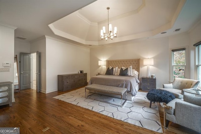 bedroom featuring crown molding, wood-type flooring, a raised ceiling, and a notable chandelier