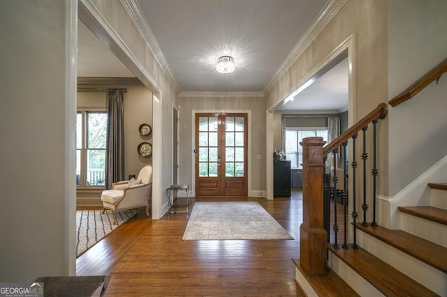 foyer entrance with french doors, a healthy amount of sunlight, crown molding, and dark wood-type flooring