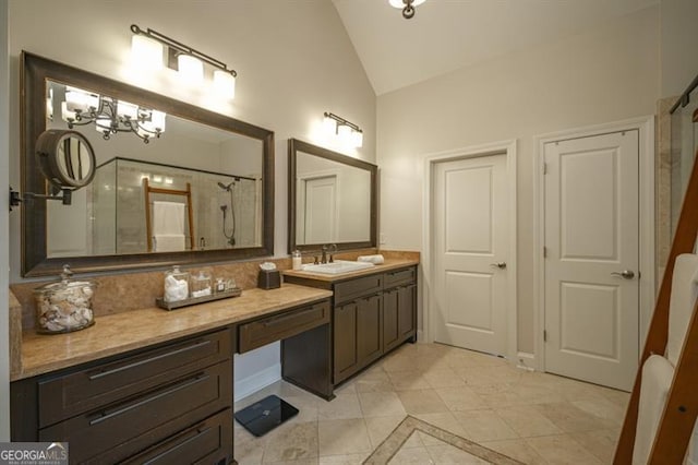 bathroom with vaulted ceiling, vanity, tiled shower, tile patterned floors, and an inviting chandelier