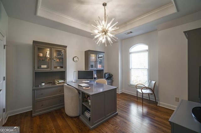 office area featuring an inviting chandelier, a tray ceiling, and dark wood-type flooring