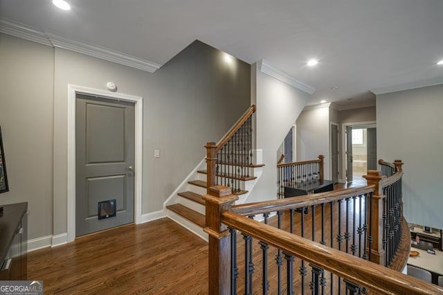 stairs with ornamental molding and hardwood / wood-style floors