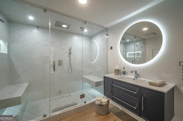 bathroom featuring wood-type flooring, vanity, and a shower with shower door