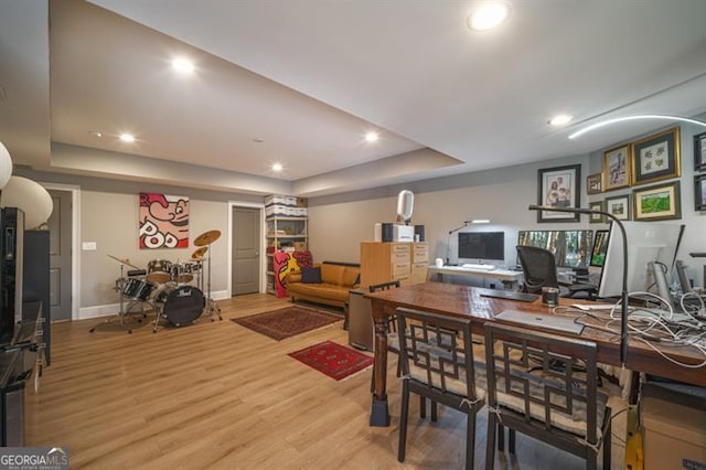 dining space featuring a raised ceiling and light hardwood / wood-style floors