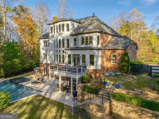 rear view of house with a yard, a patio area, and a swimming pool side deck