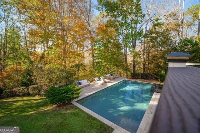 view of swimming pool featuring a yard and a patio