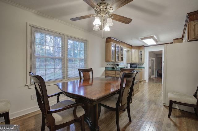 dining area featuring ceiling fan, wood-type flooring, and ornamental molding