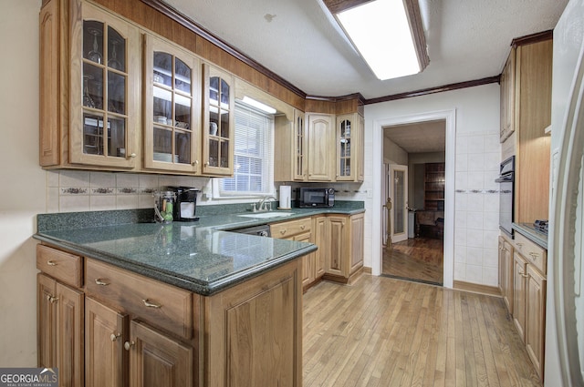 kitchen with light wood-type flooring, ornamental molding, a textured ceiling, sink, and black appliances