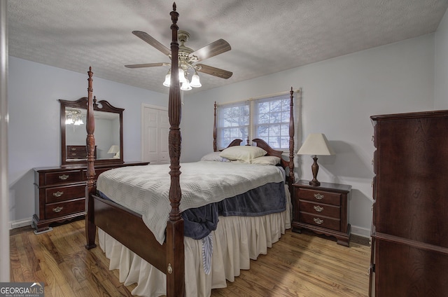 bedroom with hardwood / wood-style flooring, ceiling fan, and a textured ceiling