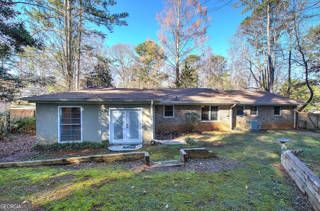 back of property featuring a yard and central air condition unit