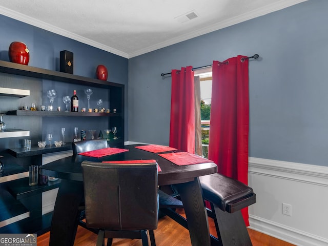 dining area featuring wood-type flooring and ornamental molding