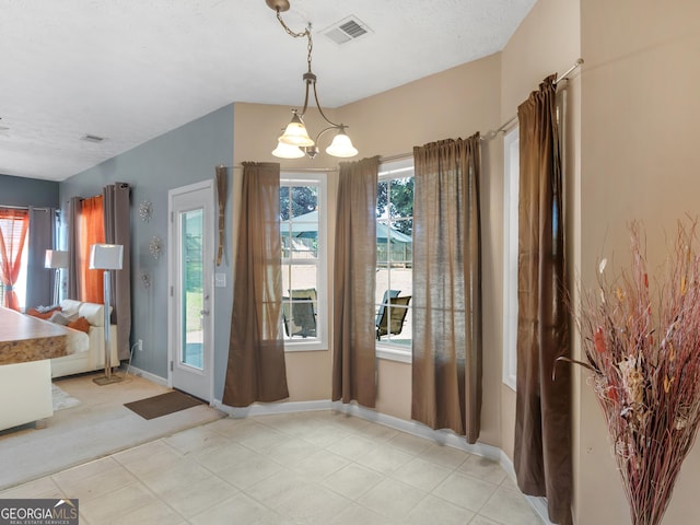 doorway to outside featuring a notable chandelier