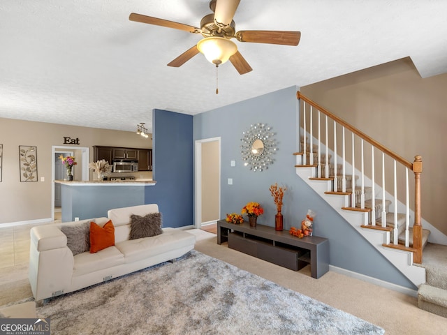 carpeted living room with ceiling fan and a textured ceiling