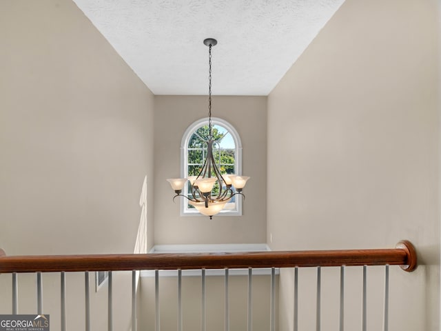 room details featuring a textured ceiling and an inviting chandelier