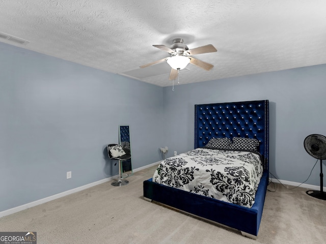 bedroom with ceiling fan, carpet, and a textured ceiling