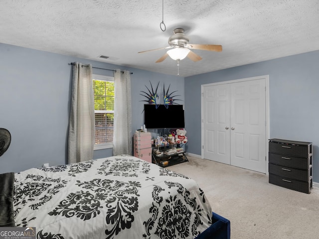 bedroom featuring ceiling fan, a closet, and a textured ceiling