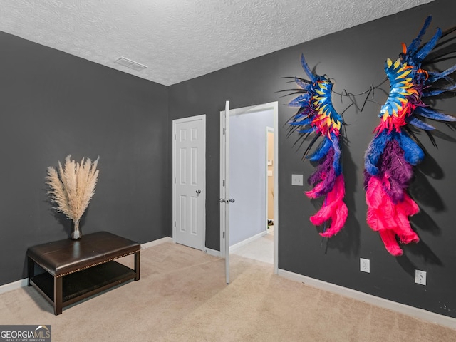 interior space featuring a textured ceiling and light carpet