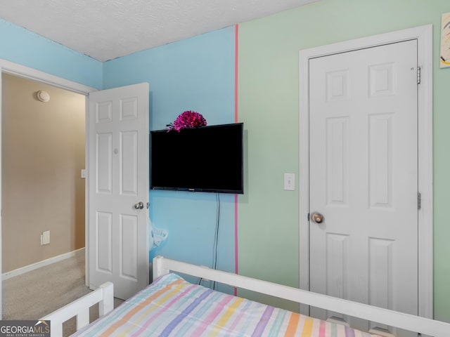 carpeted bedroom featuring a textured ceiling