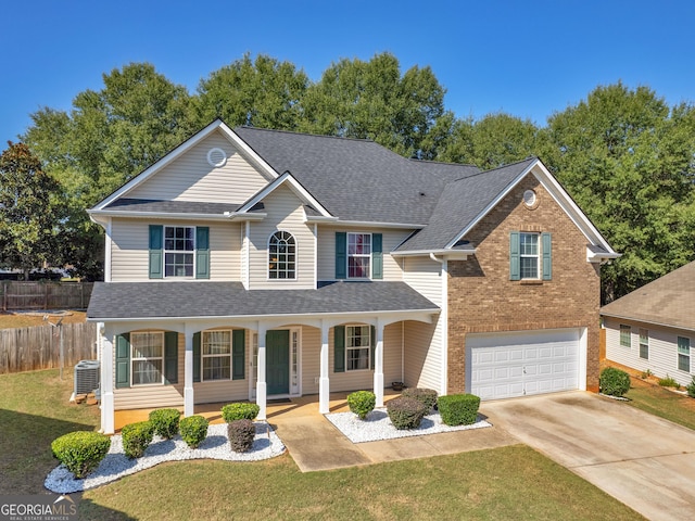 view of property featuring central AC unit, a garage, covered porch, and a front yard