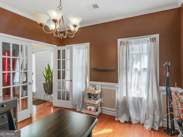 dining room featuring ornamental molding, french doors, a chandelier, and wood-type flooring