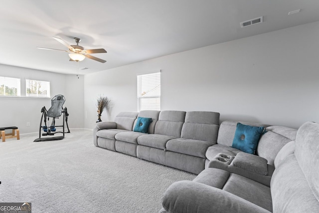 carpeted living room with a wealth of natural light and ceiling fan