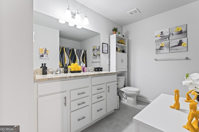 bathroom featuring tile patterned flooring, vanity, and toilet