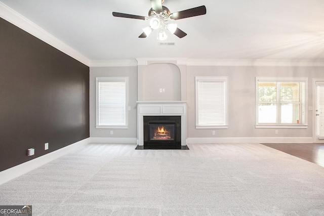 unfurnished living room featuring light colored carpet, ceiling fan, and crown molding