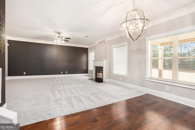 unfurnished living room featuring ceiling fan with notable chandelier, light hardwood / wood-style flooring, and crown molding