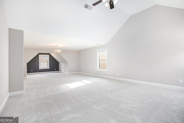 bonus room with plenty of natural light, light colored carpet, and lofted ceiling