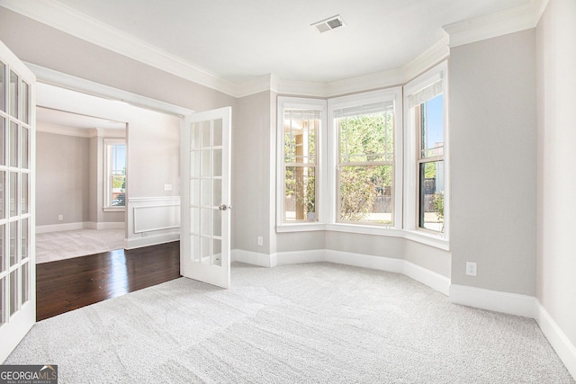 empty room featuring a wealth of natural light, crown molding, and french doors