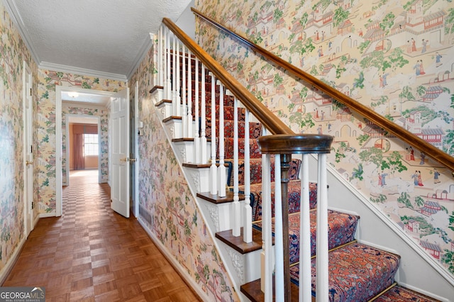 stairway with crown molding, a textured ceiling, and parquet flooring