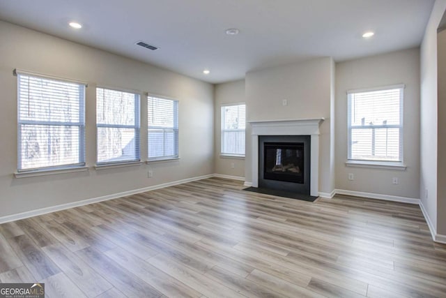 unfurnished living room with a healthy amount of sunlight and light wood-type flooring