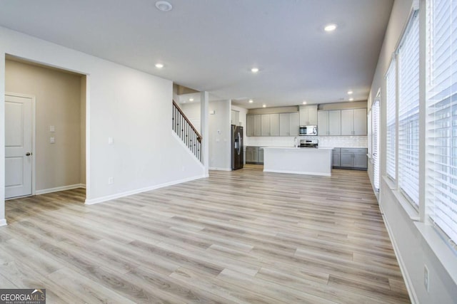 unfurnished living room with plenty of natural light and light hardwood / wood-style floors