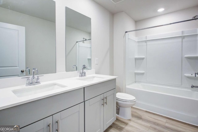 full bathroom with toilet, hardwood / wood-style floors, vanity, and tub / shower combination