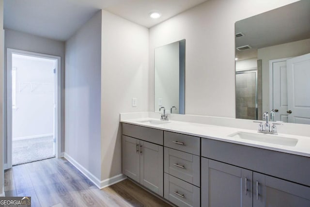 bathroom featuring a shower with door, vanity, and wood-type flooring