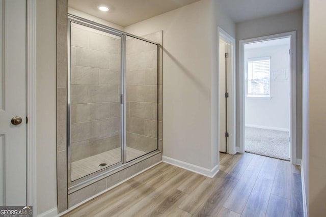 bathroom with hardwood / wood-style floors and an enclosed shower