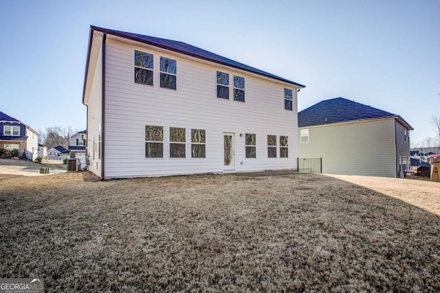 back of property with a yard and central air condition unit