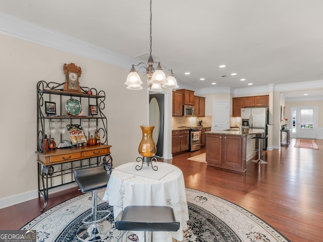 dining area featuring crown molding, dark hardwood / wood-style flooring, and a notable chandelier