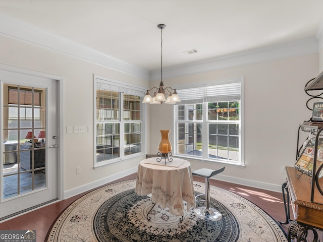 dining room featuring dark hardwood / wood-style floors, an inviting chandelier, and crown molding