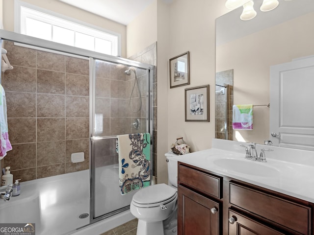 bathroom featuring tile patterned floors, vanity, an enclosed shower, and toilet