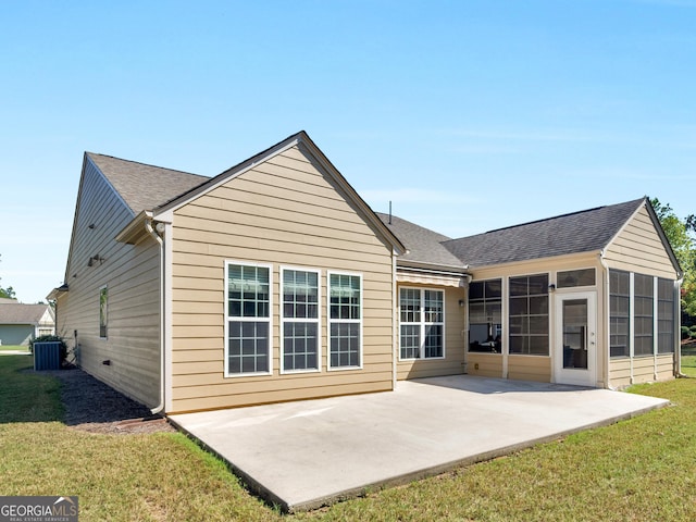 rear view of house featuring a lawn, a sunroom, a patio, and central AC