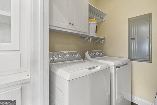 laundry room featuring cabinets, washing machine and dryer, and electric panel