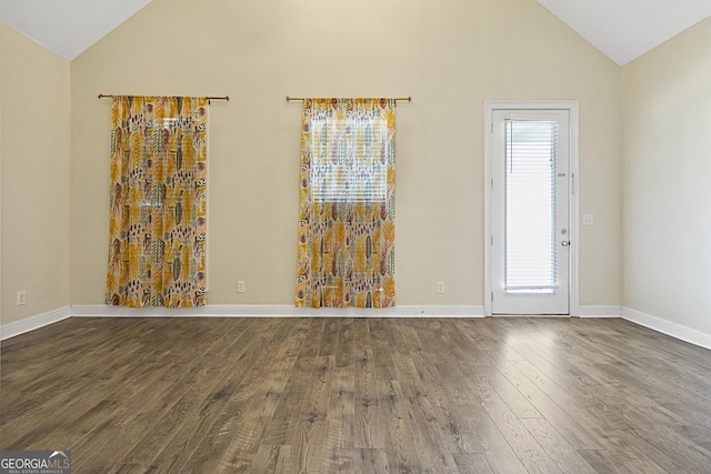 spare room with dark hardwood / wood-style flooring and lofted ceiling