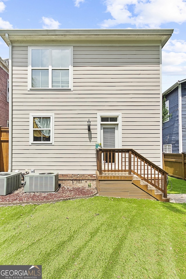 back of property featuring a lawn and cooling unit