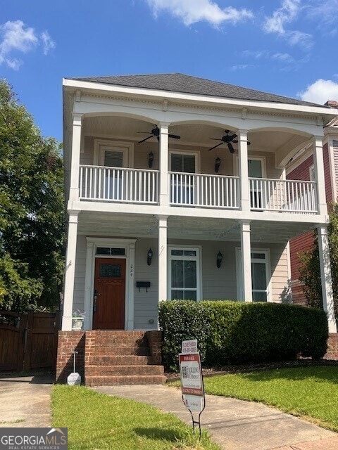 neoclassical home with a balcony and ceiling fan