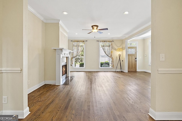 unfurnished living room featuring hardwood / wood-style floors, ceiling fan, and crown molding