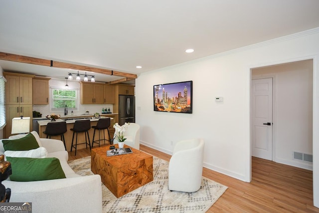 living room featuring light hardwood / wood-style flooring and ornamental molding